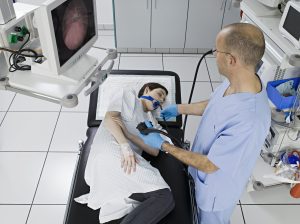 doctor examing young woman with endoscope