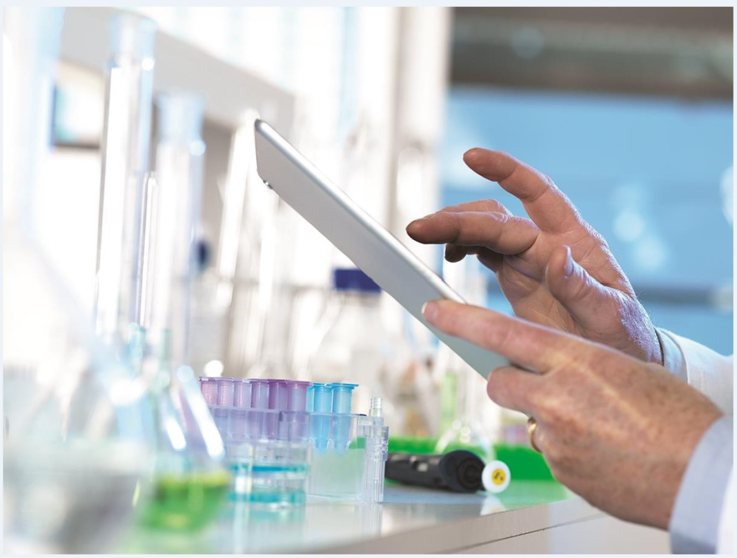 Scientist typing on tablet